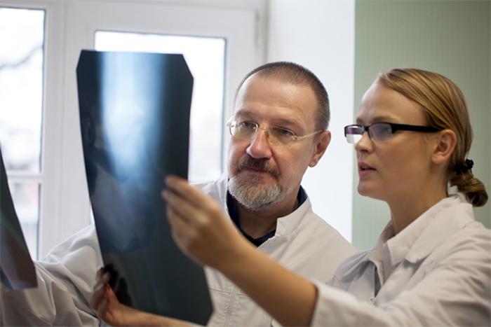 two people examining an x-ray