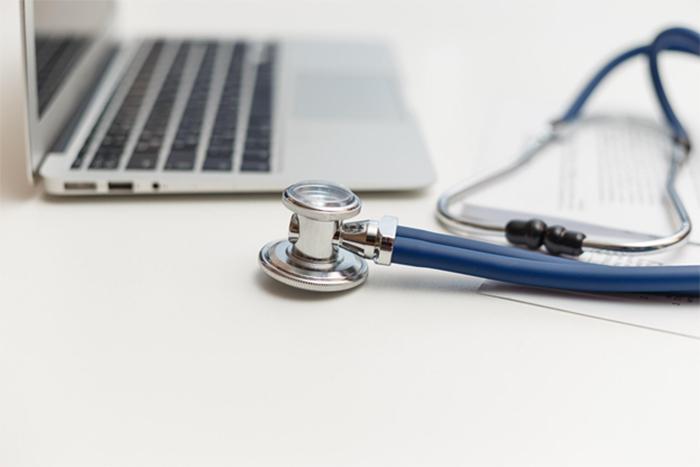 closeup of a stethoscope next to a laptop