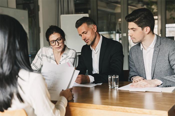 four people around a table looking at paperwork